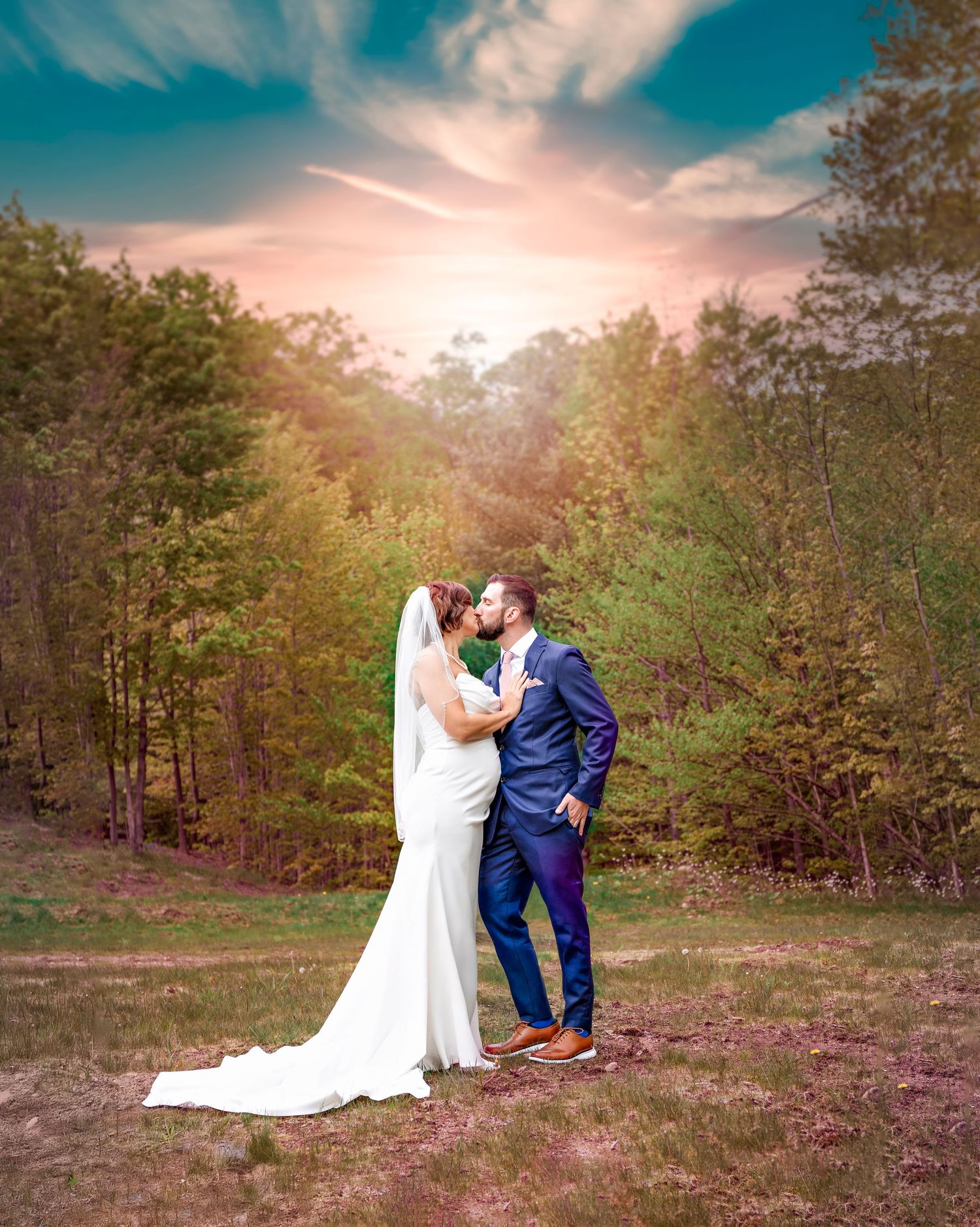 Newlyweds share intimate moment in field during golden hour wedding photography session.