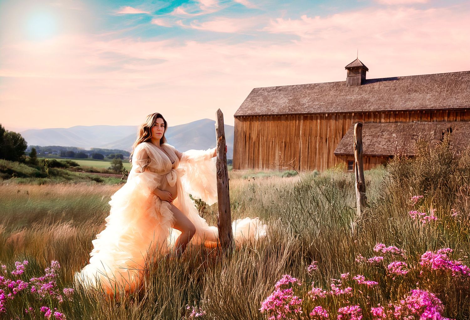 Dreamy countryside photoshoot with pink dress and rustic barn backdrop at golden hour.
