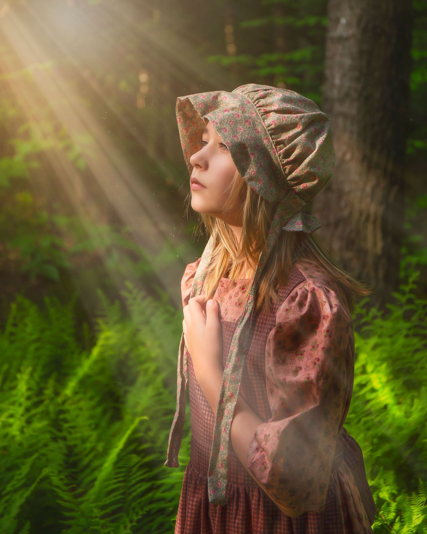 Ethereal forest portrait with sunbeams streaming through trees and vintage dress.