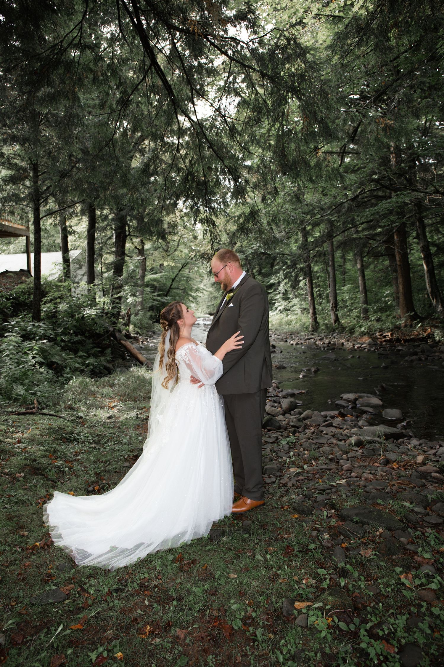 Elegant wedding couple dances in enchanted forest setting.