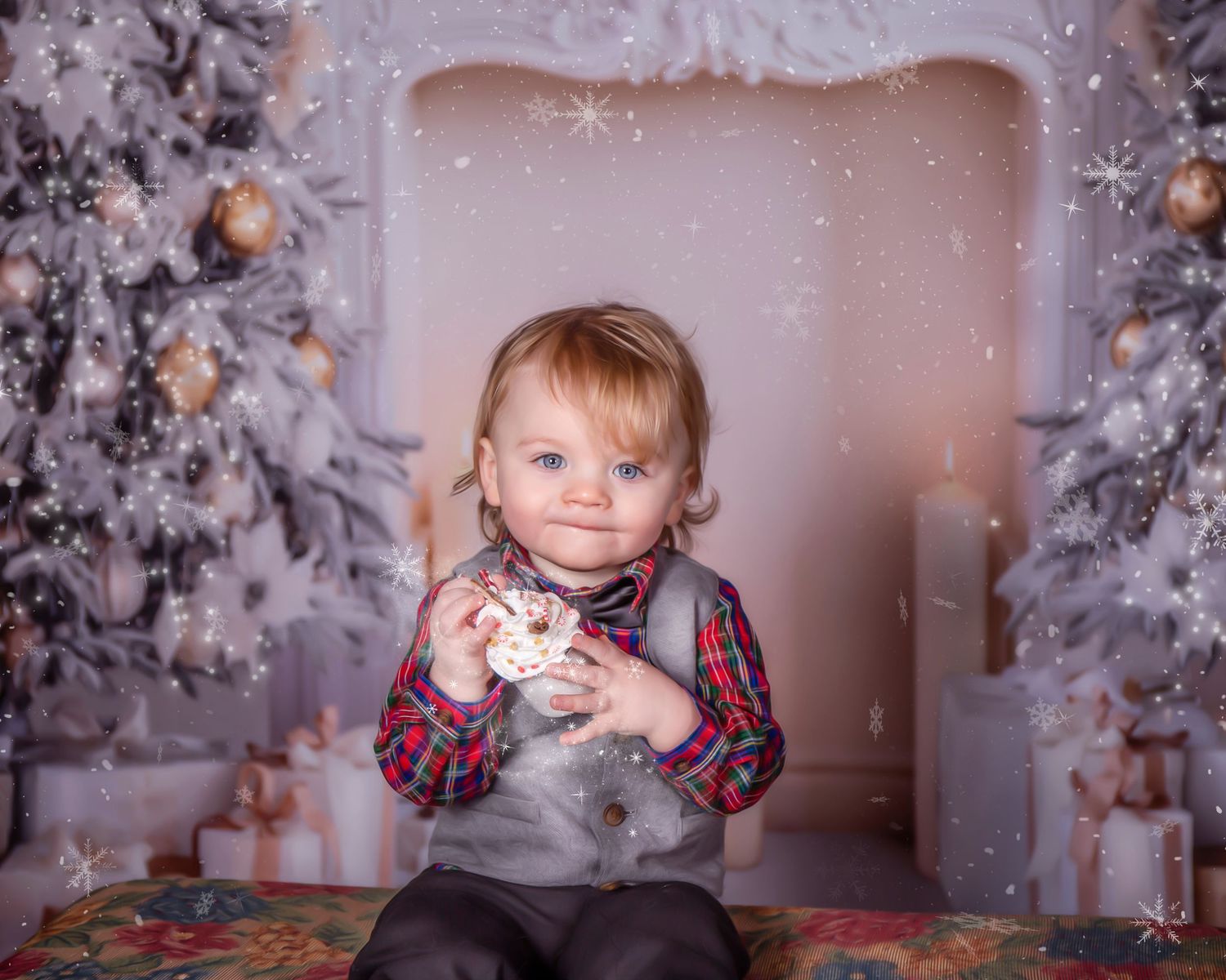 A child sits among decorated Christmas trees and holiday decor holding a small ornament in a festive winter setting.