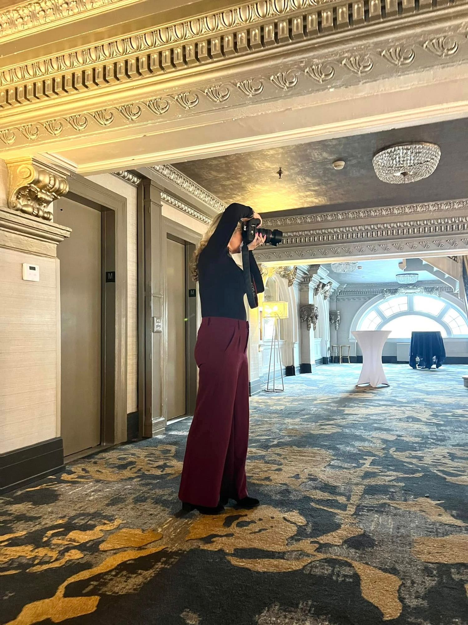 Ornate hotel ballroom interior with patterned carpet and elegant architectural details.