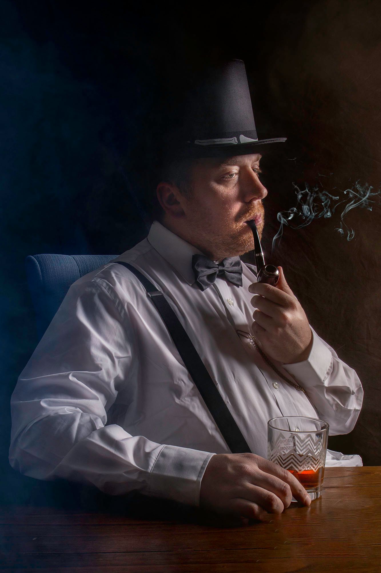 Moody sequence of someone in white shirt and hat smoking while sitting at wooden table with drink.
