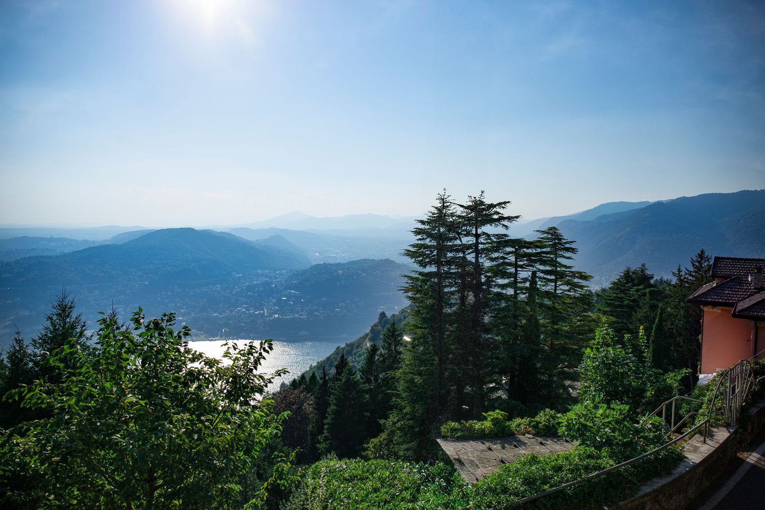 Panoramic mountain landscape with evergreen trees and misty valleys stretching across multiple connected scenic views.