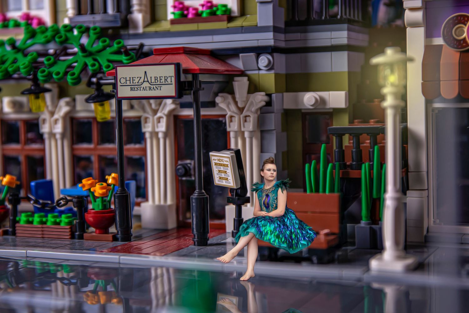 Miniature LEGO city street scene with detailed storefronts and architecture.