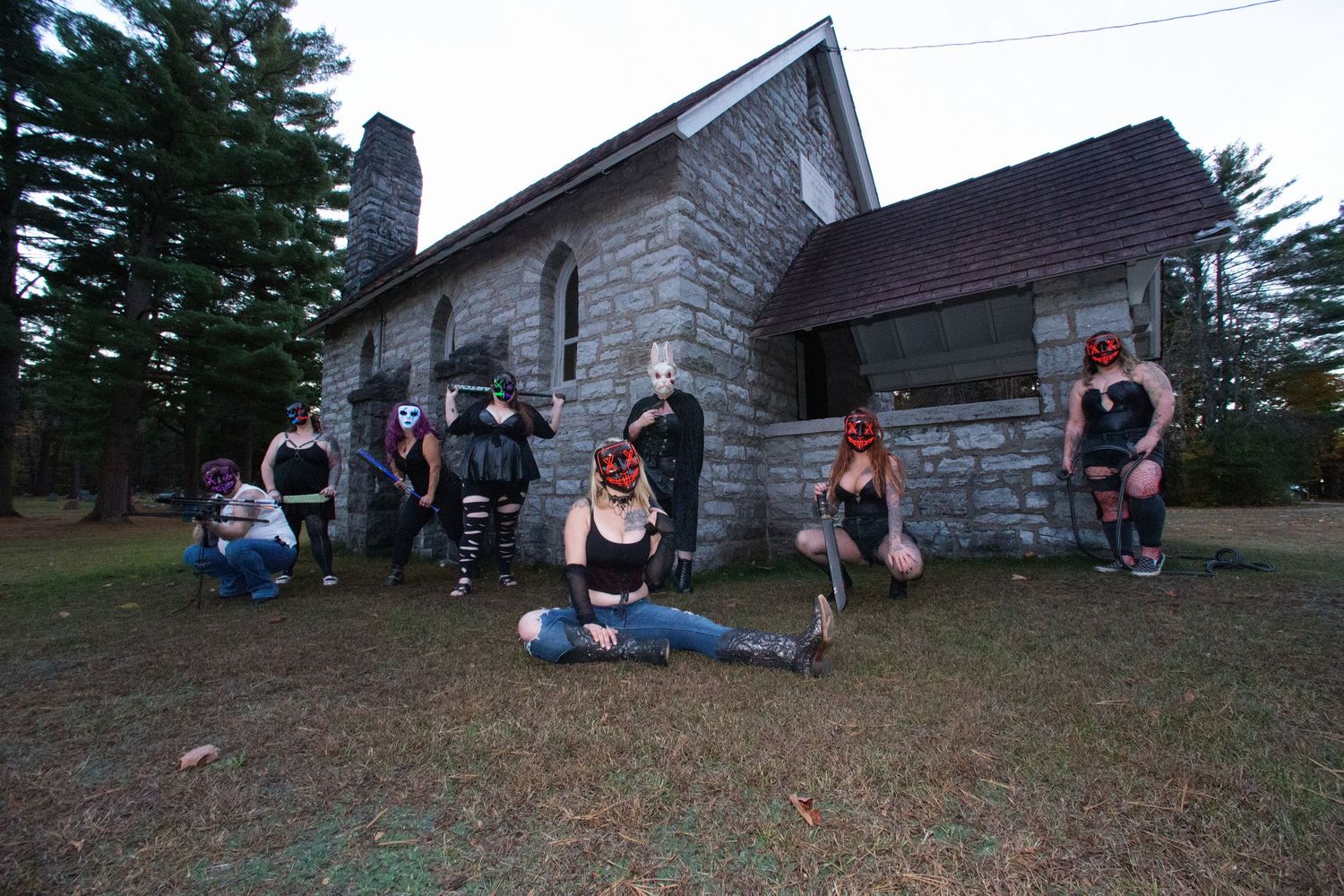 Group photo session outside a rustic wooden building on a hillside.