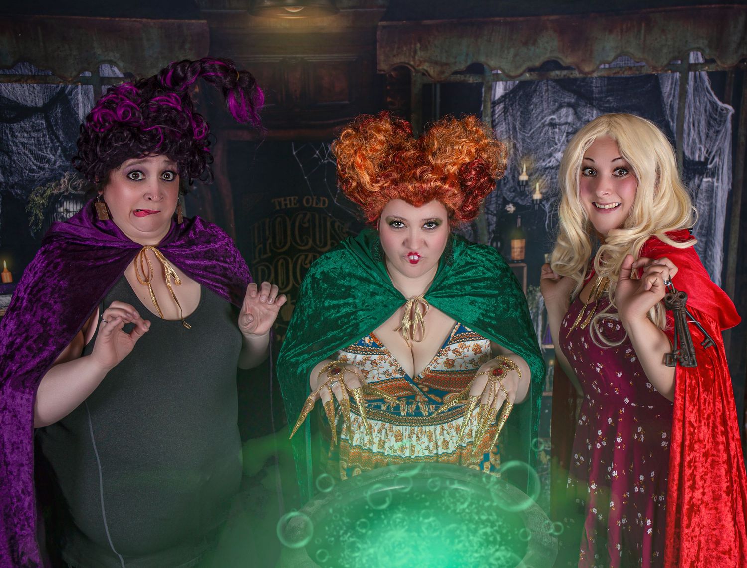 Dramatic group photo with colorful lighting and theatrical costumes.