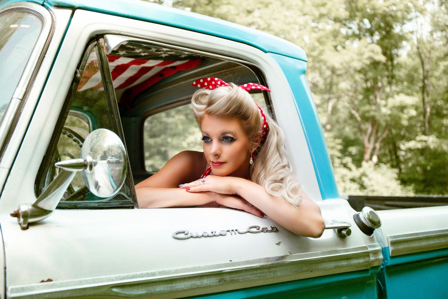 Vintage-inspired photoshoot featuring a classic turquoise truck with retro styling and pin-up aesthetic.