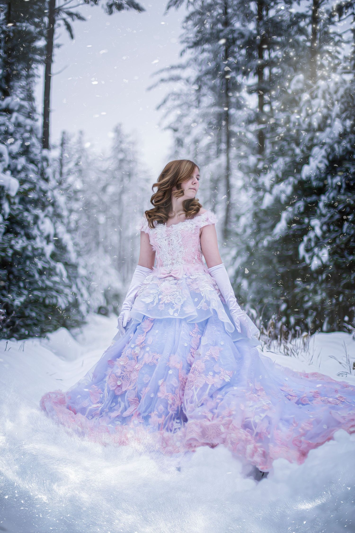 A flowing pastel pink and blue dress twirls gracefully in a snowy winter forest setting.