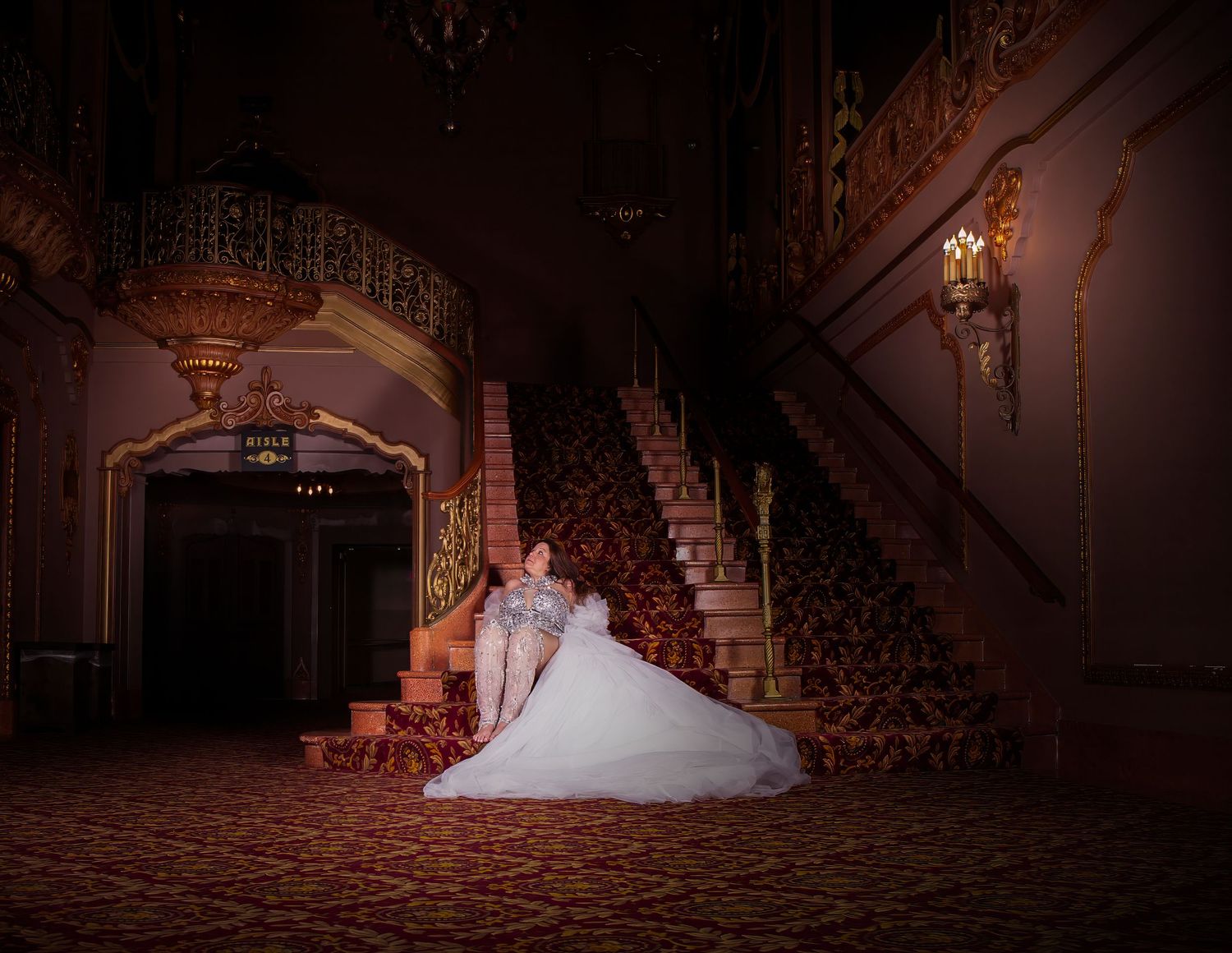 A dramatic bridal portrait on vintage stairs with warm ambient lighting.