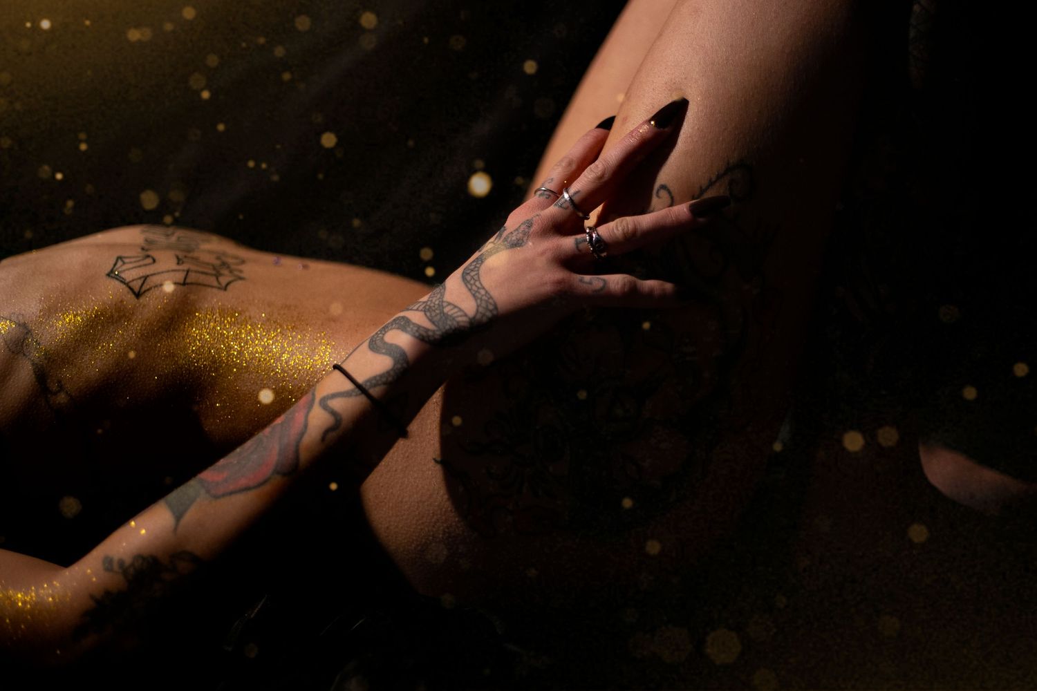 Close-up shot of hands preparing sushi rolls on a dark surface with delicate precision and artistry.