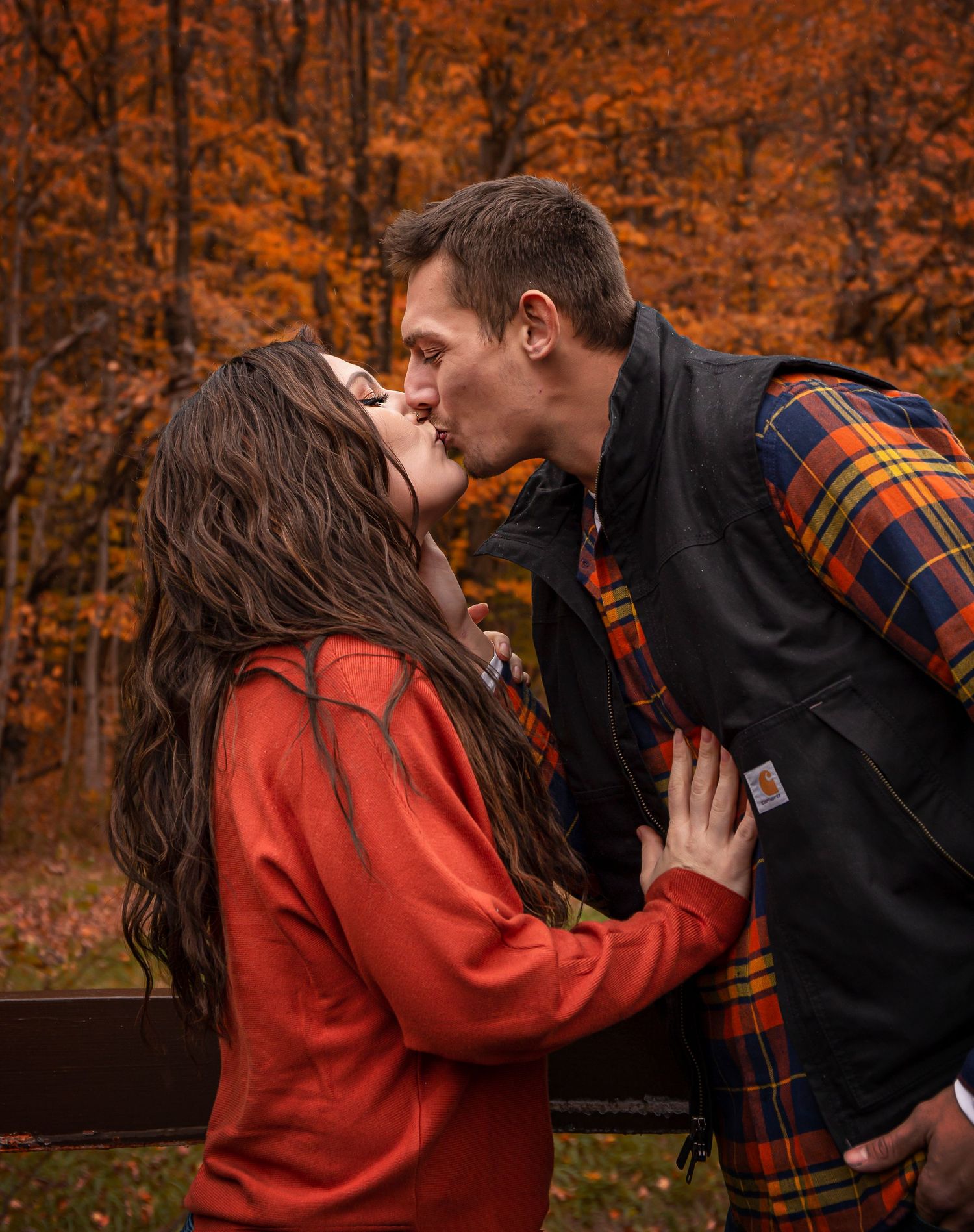 Romantic autumn photoshoot with fallen leaves in warm orange tones.