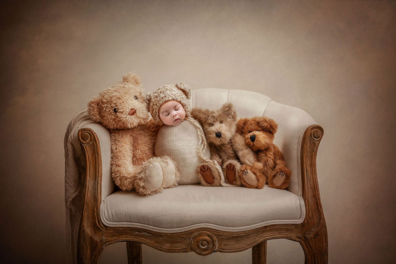 Collection of teddy bears arranged on an elegant cream-colored vintage settee.