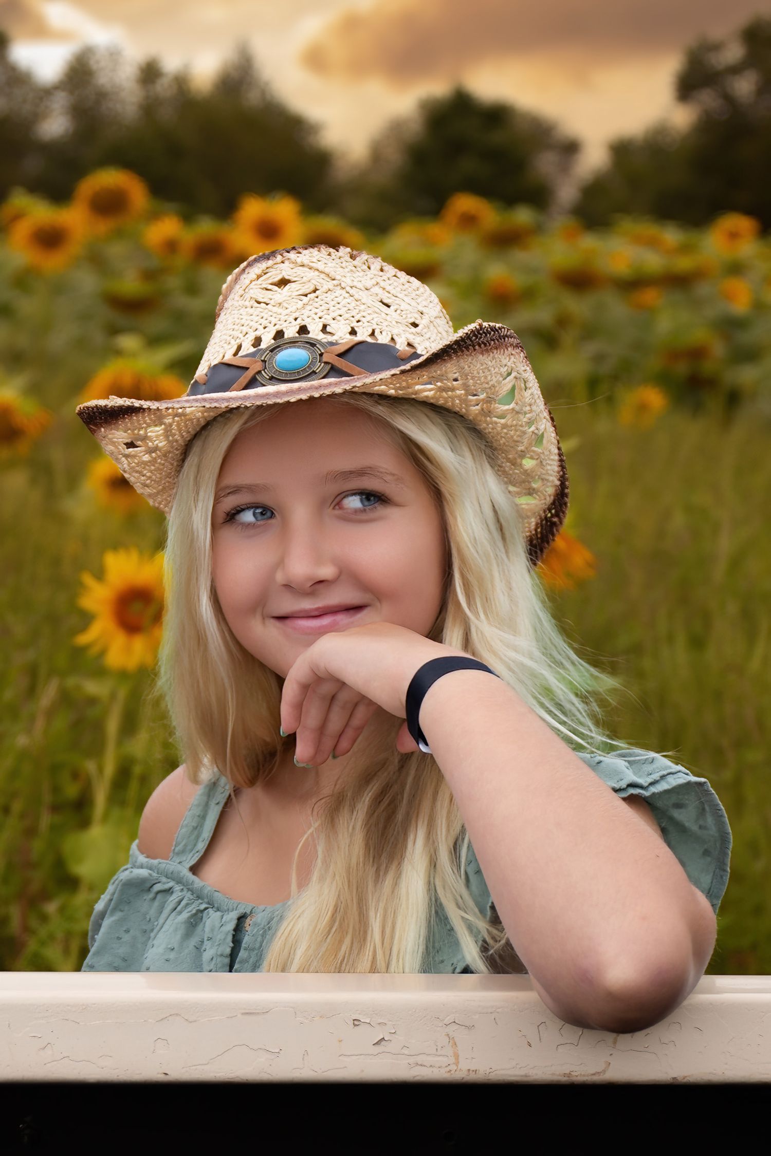 Portrait series in a sunflower field showing someone in a straw hat and blue dress during golden hour.