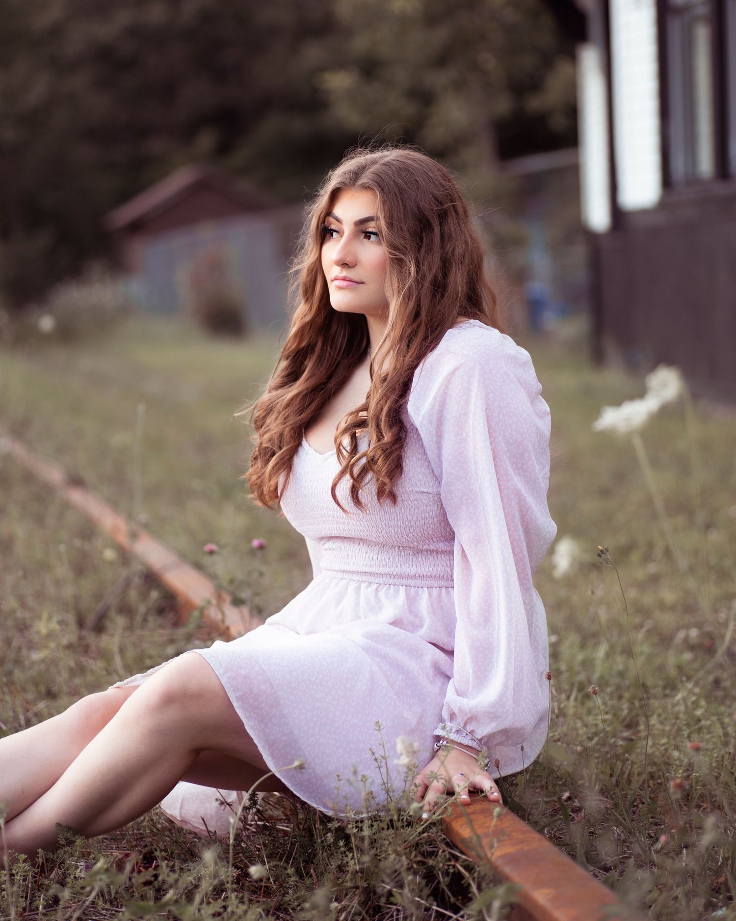 Portrait session in white dress among tall grass during golden hour.