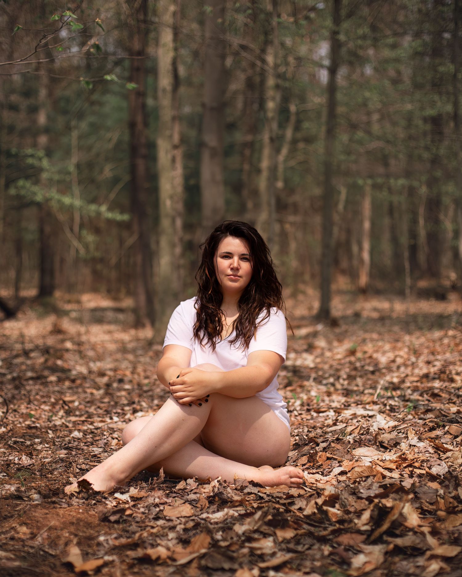 Artistic autumn portrait series on a bed of fallen leaves in a wooded setting.