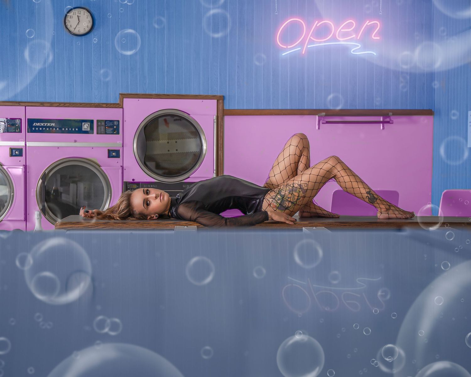 Neon-lit laundromat interior with pink and blue lighting creating a dreamy atmosphere.