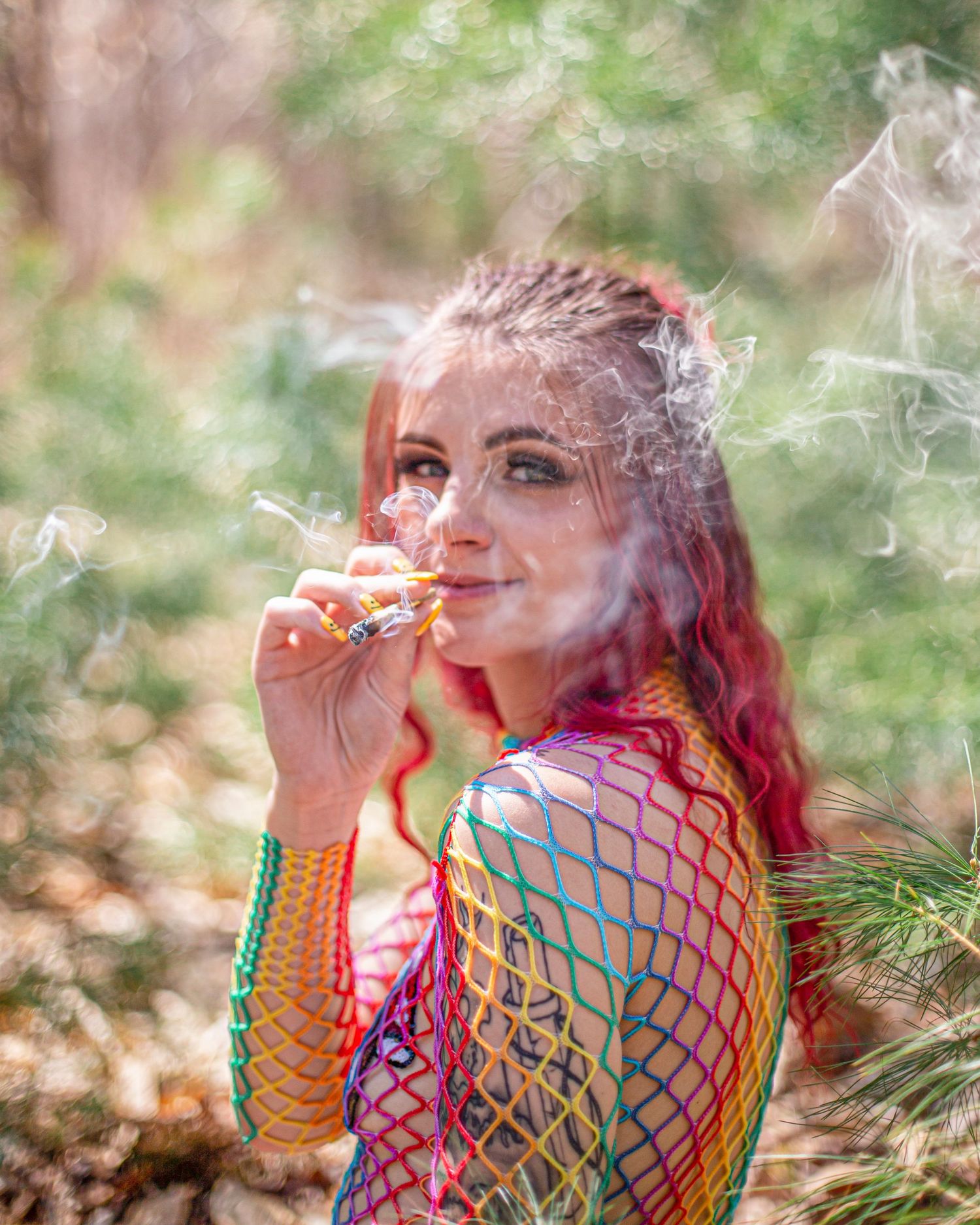 Colorful smoke effects create a dreamy atmosphere in an outdoor portrait session.