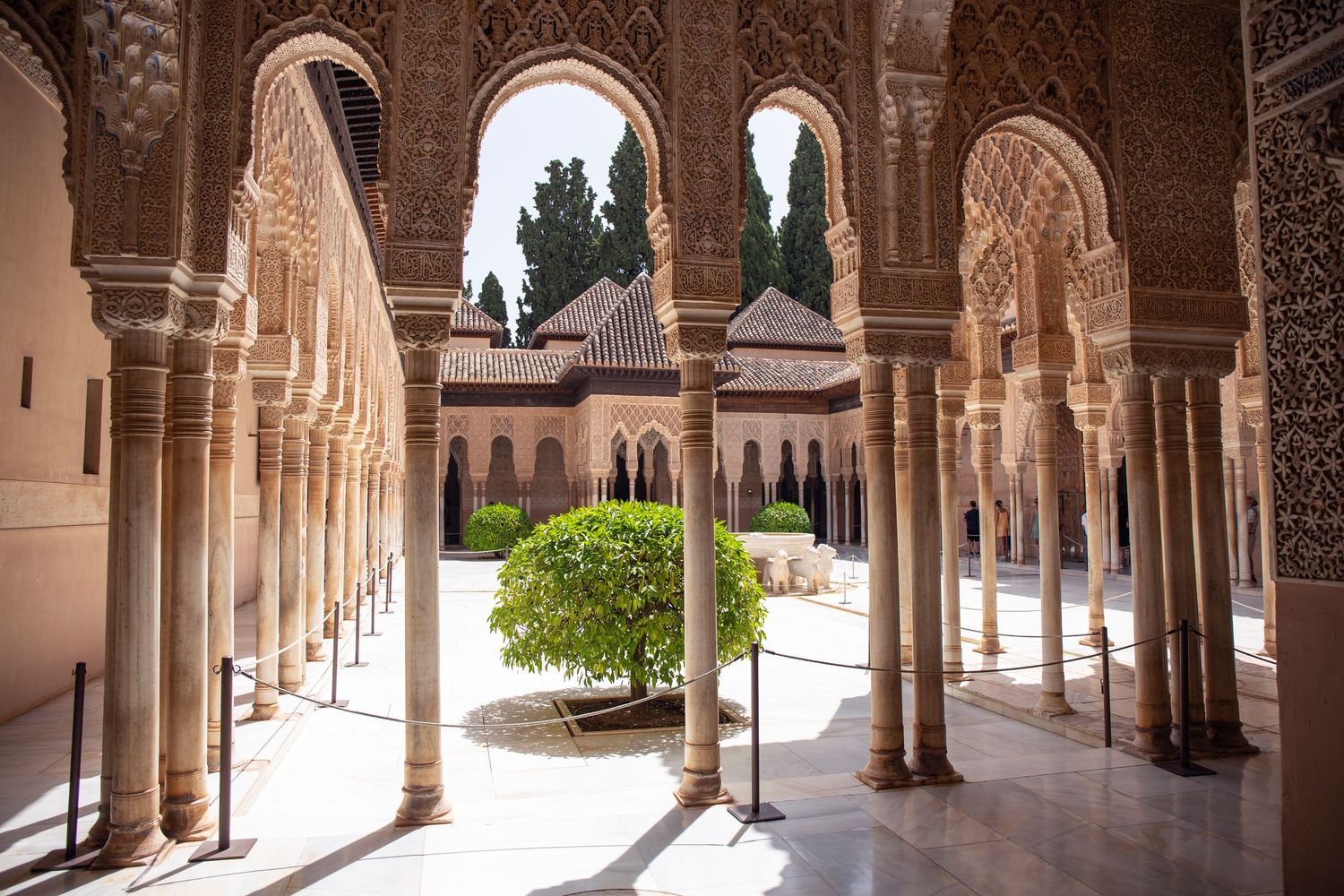 Ornate arched colonnade with Islamic architectural details in the Alhambra palace complex of Granada, Spain.