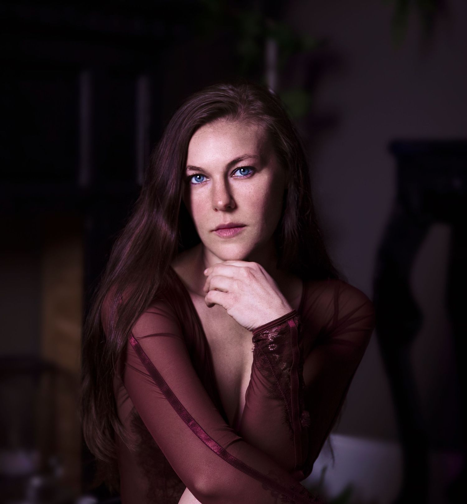 Moody portrait series with dramatic low-key lighting in burgundy tones.