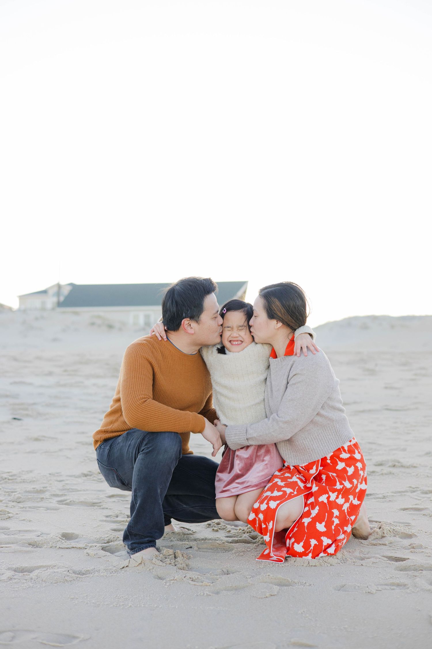 A tender family moment shared between three people on the beach.