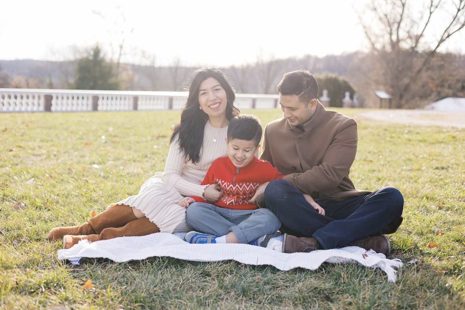 Family members share quality time together on a blanket outdoors.