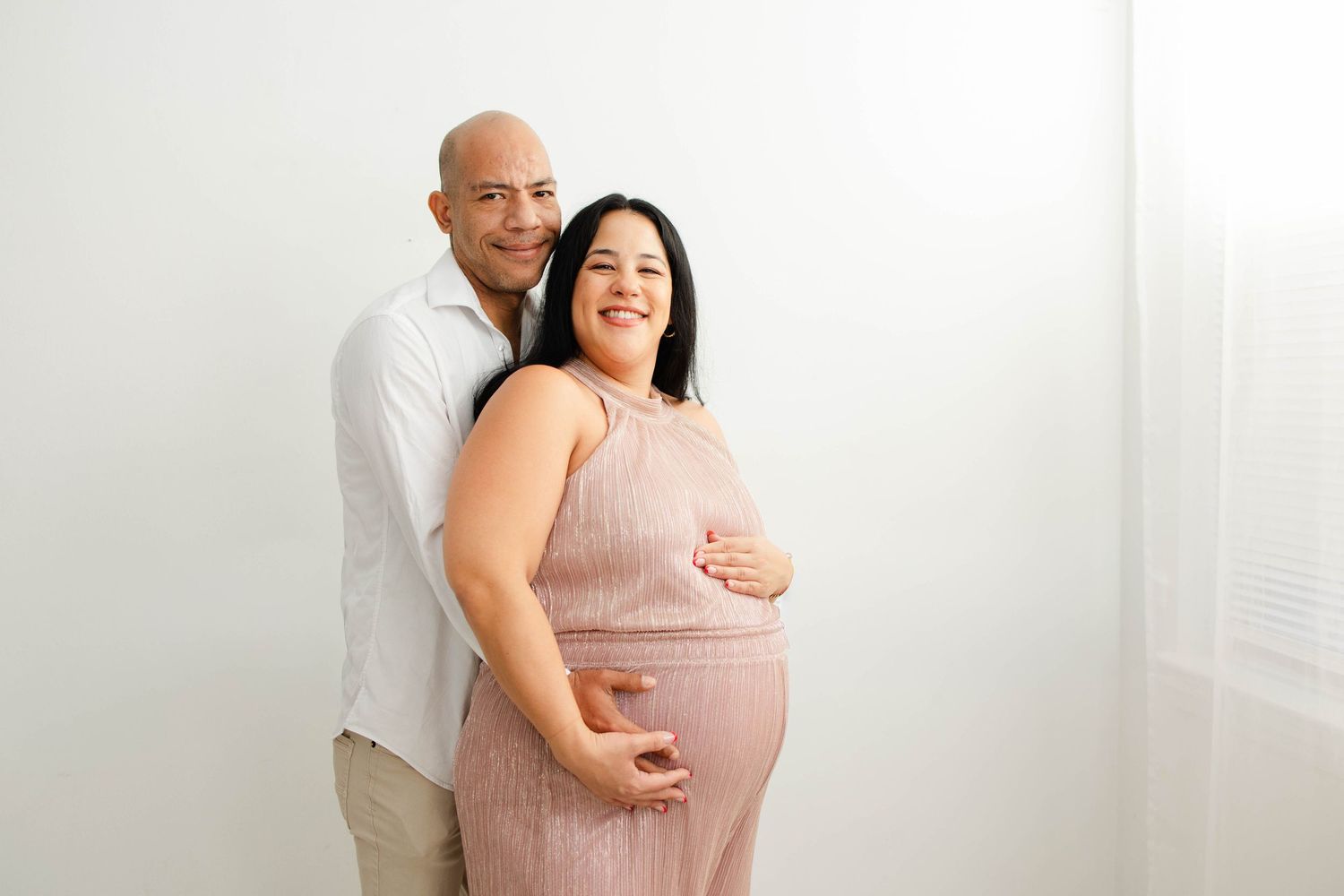 Happy couple poses for maternity photos showing affection and joy.