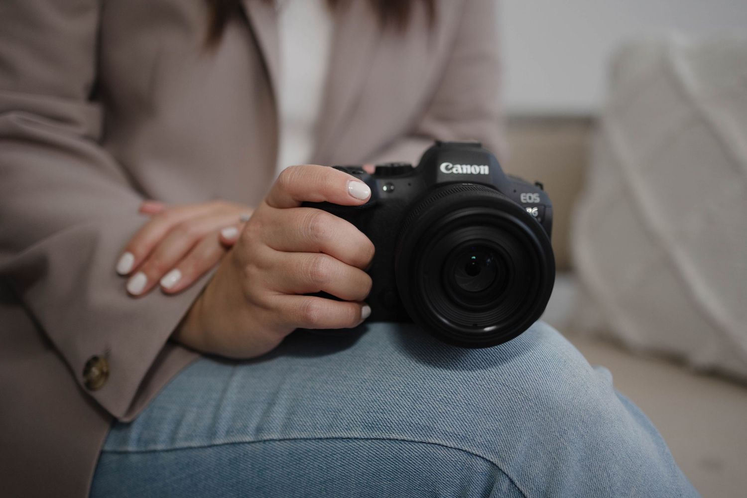 Close-up shots of hands holding a Canon camera against neutral background.