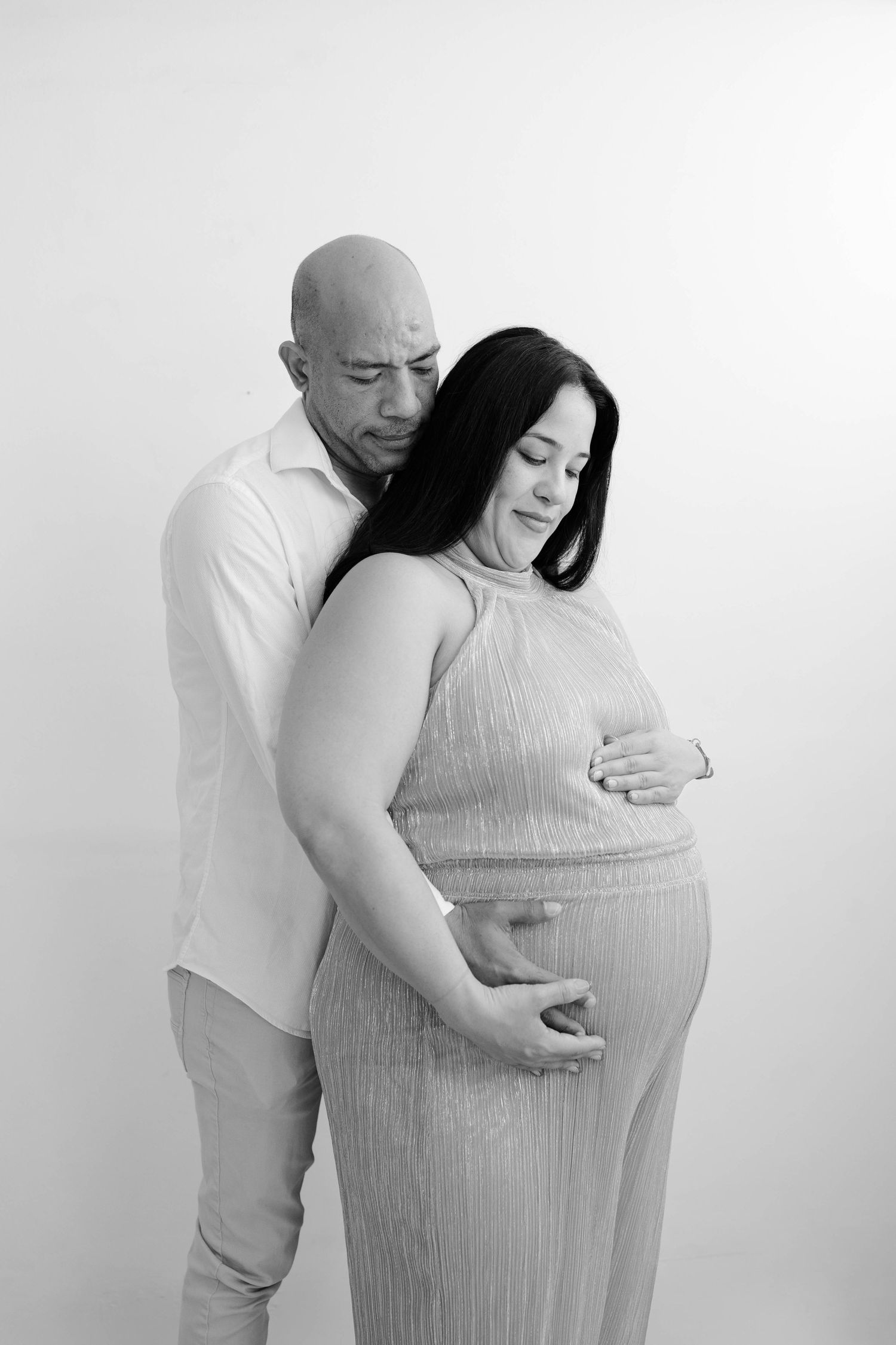 Black and white maternity photos capturing intimate moments between expectant parents.