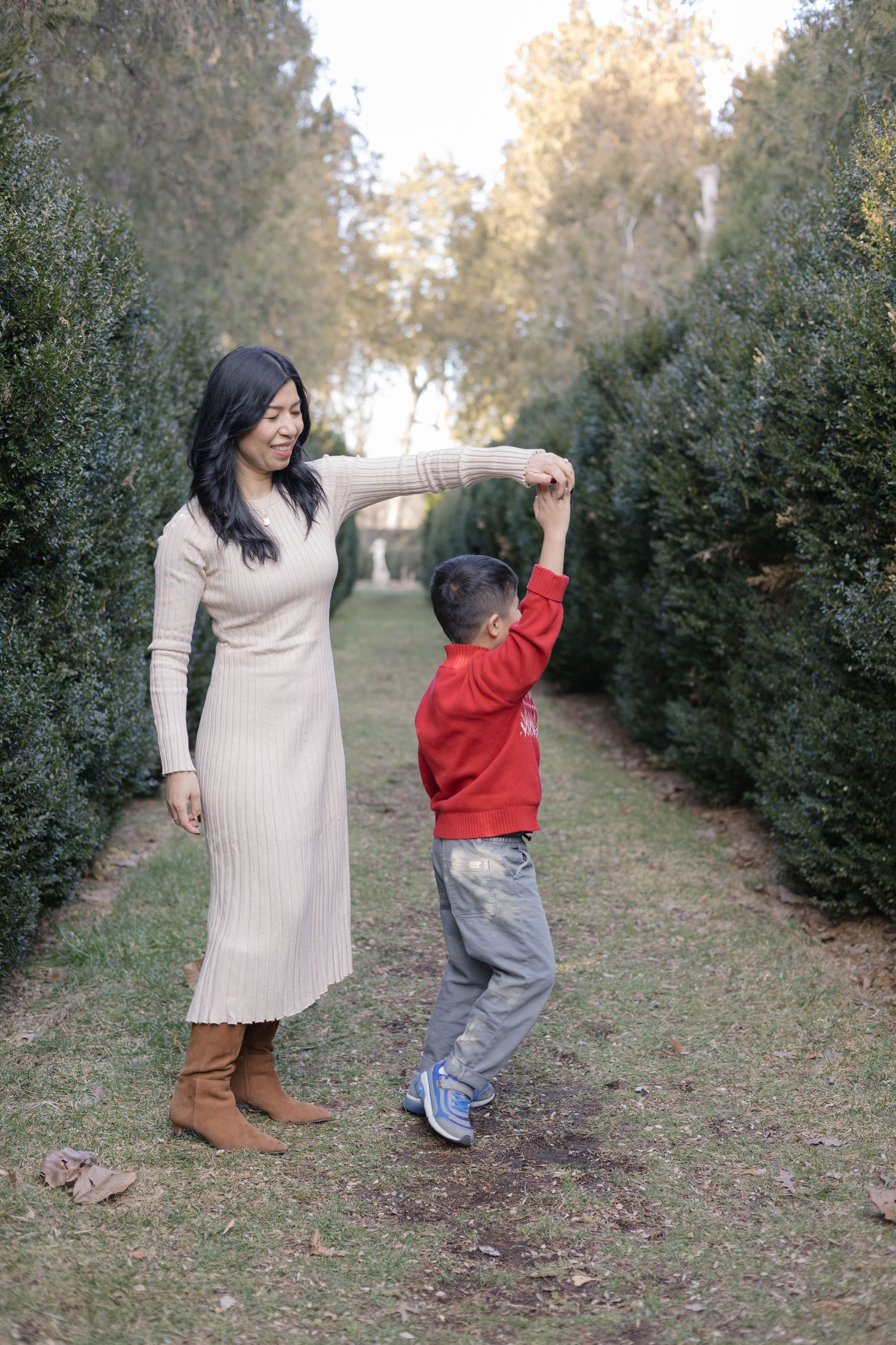A candid family photo showing joyful interaction in a Christmas tree farm setting.