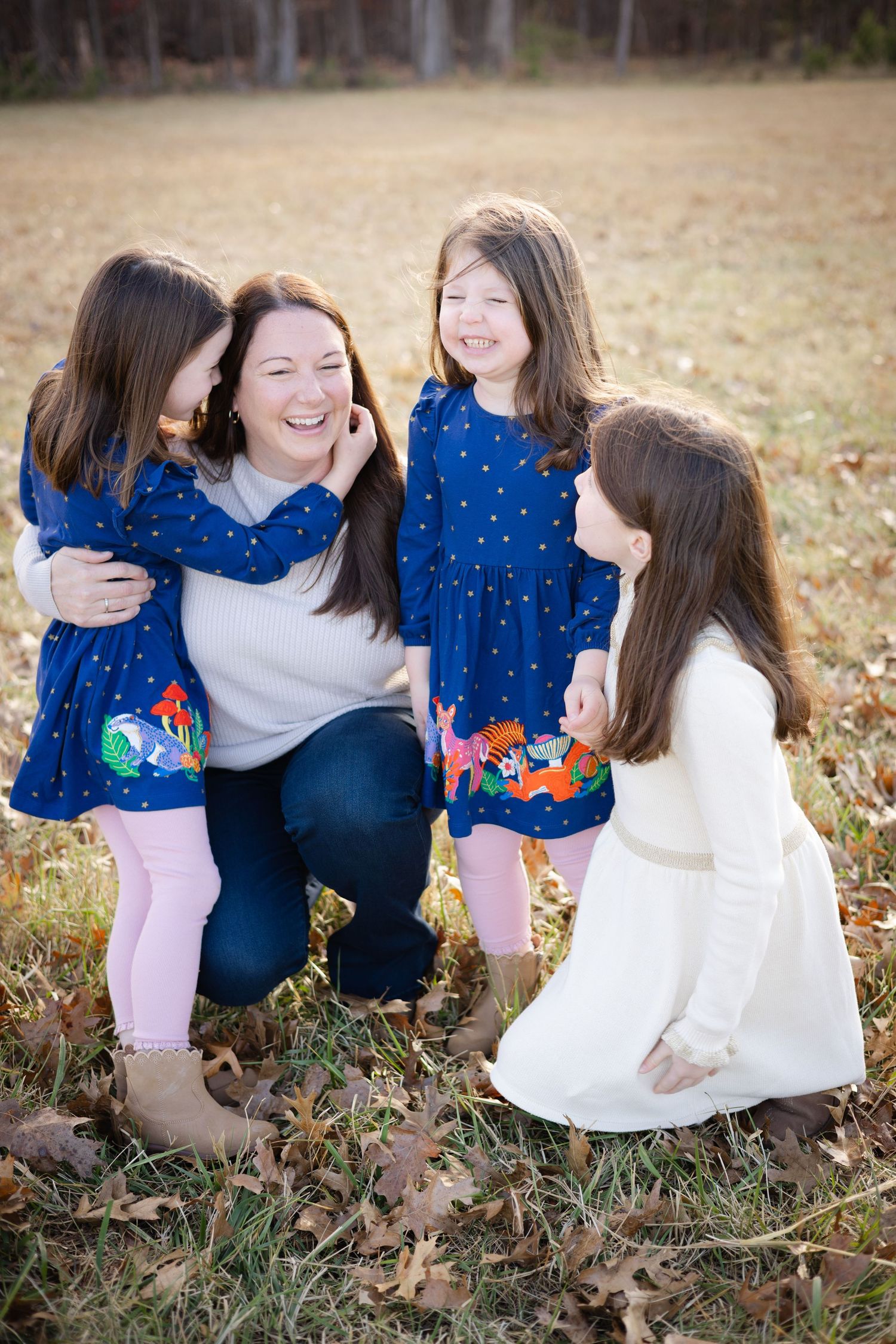Family enjoying candid moments together on fallen autumn leaves.