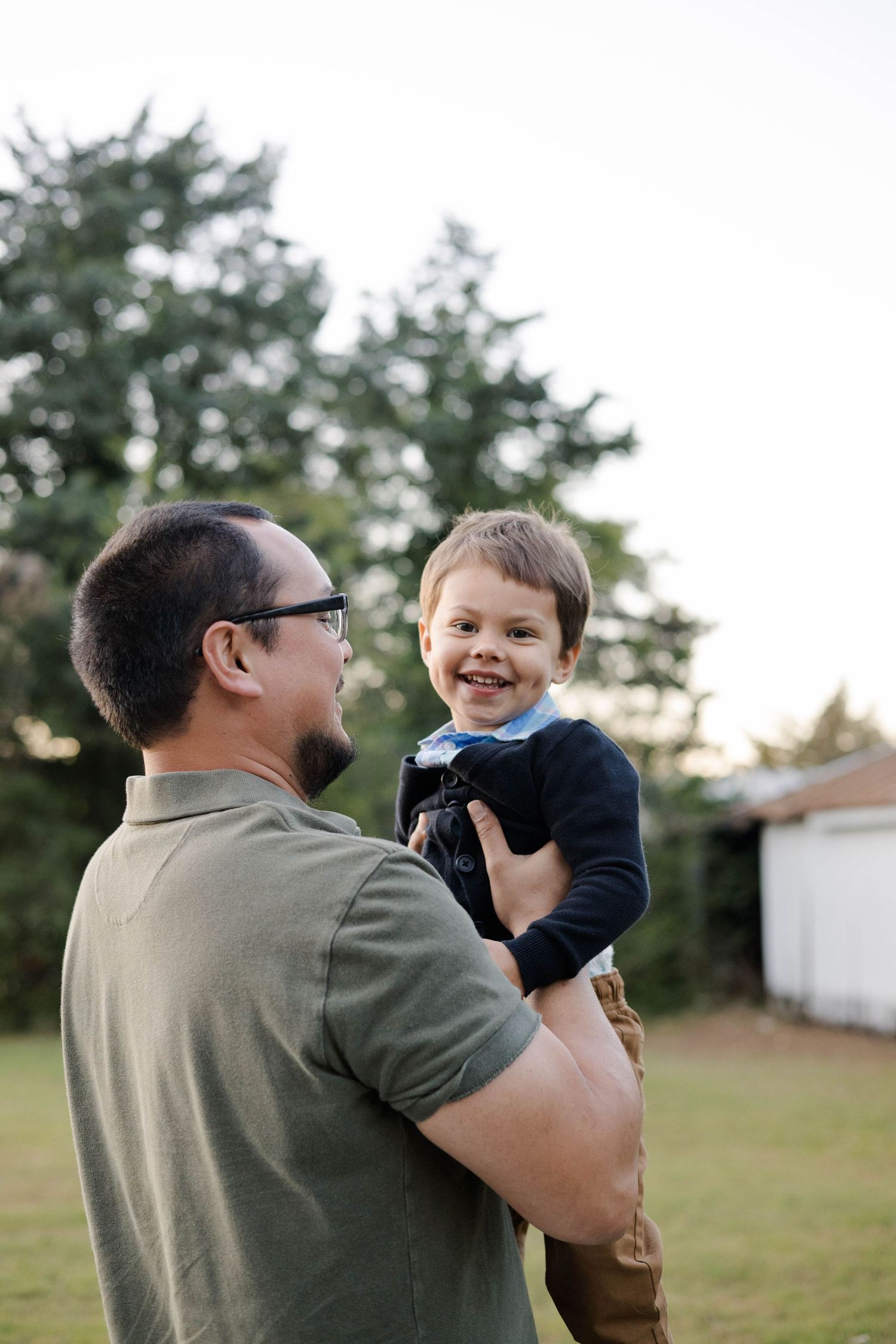 Playful outdoor portrait session showing joyful interactions in a backyard setting.