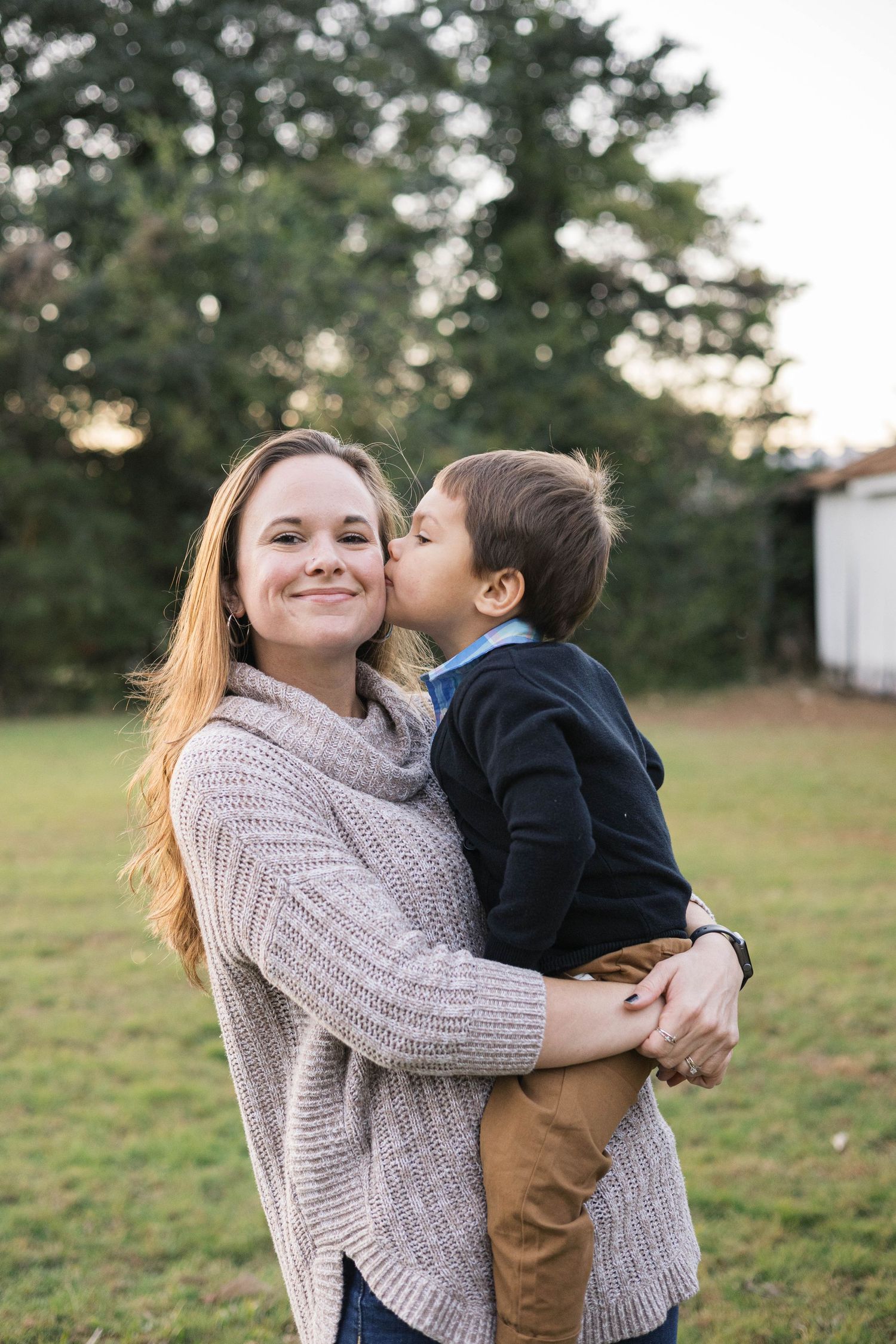 Sweet candid moments captured during outdoor family photo session in casual autumn attire.