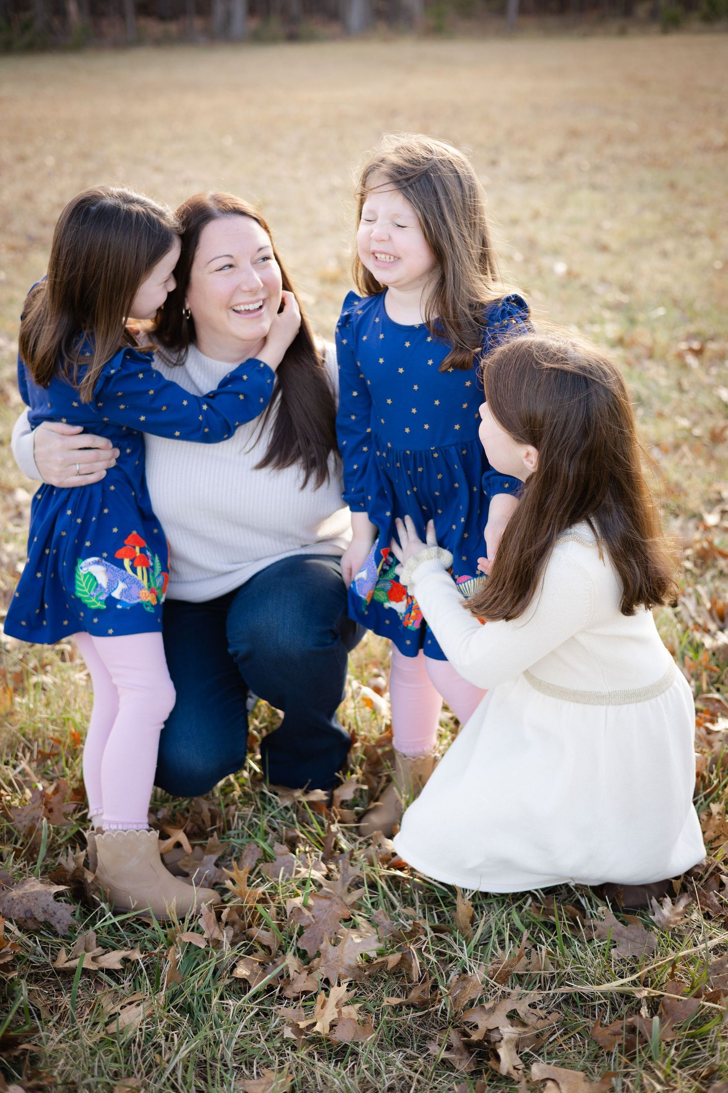Family sharing joyful moments while sitting in fall leaves.
