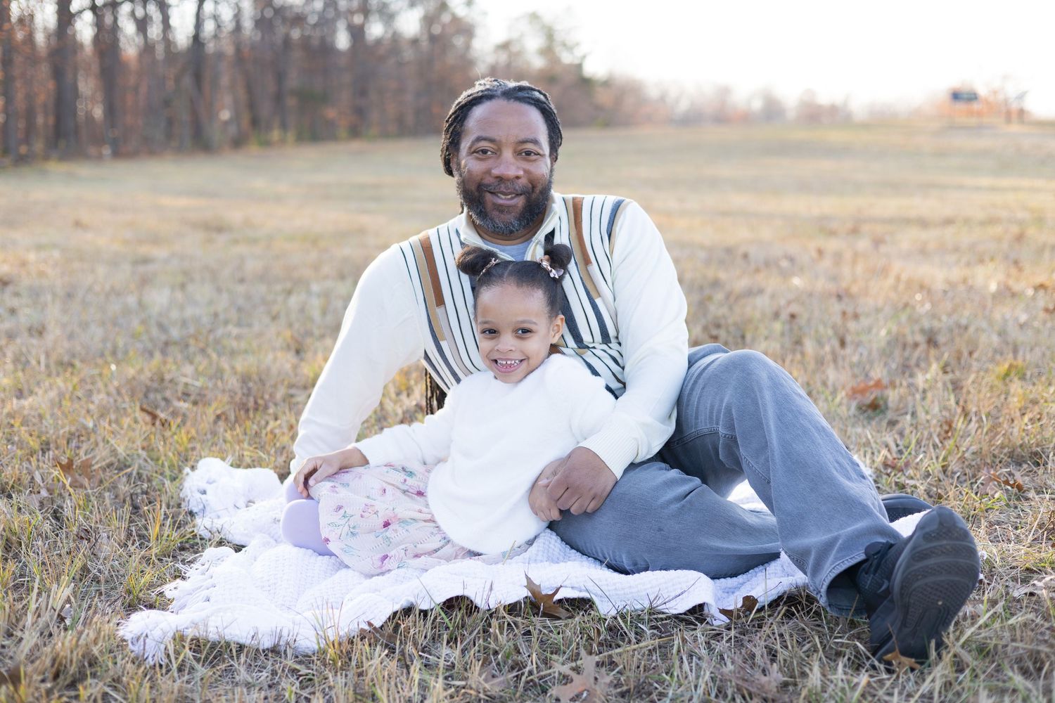 Relaxed family photography session in field with warm sunset lighting.