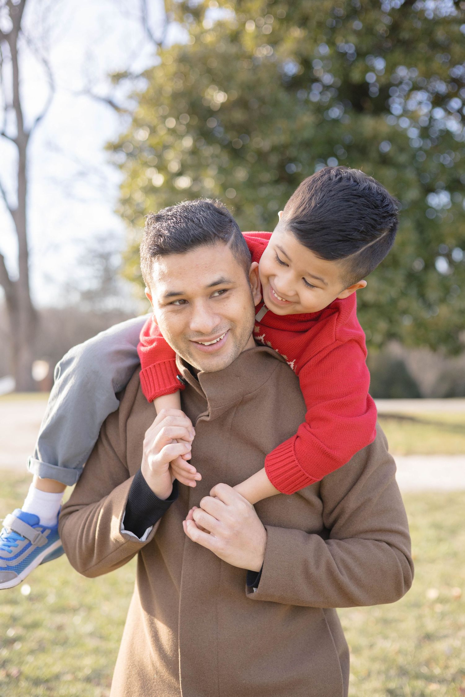 A joyful piggyback ride moment captured in a sunlit field.
