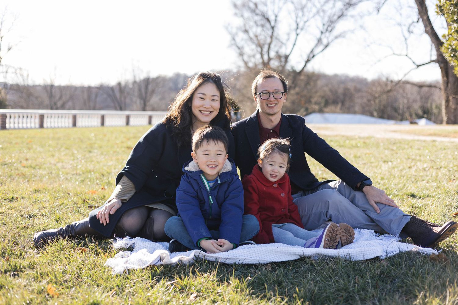 Candid family moment captured while lounging on a blanket outdoors.