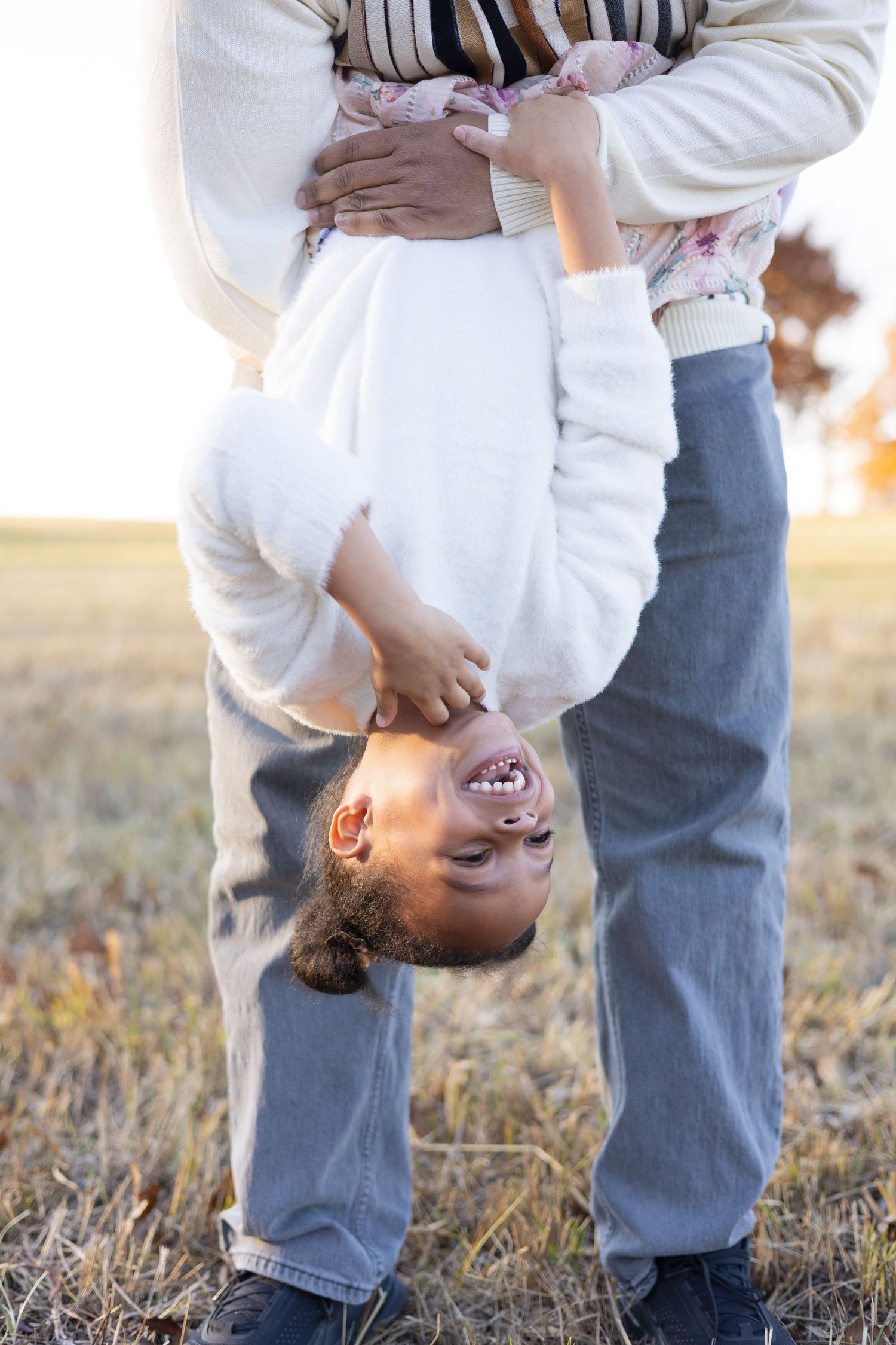 Playful upside-down pose during outdoor family photoshoot.