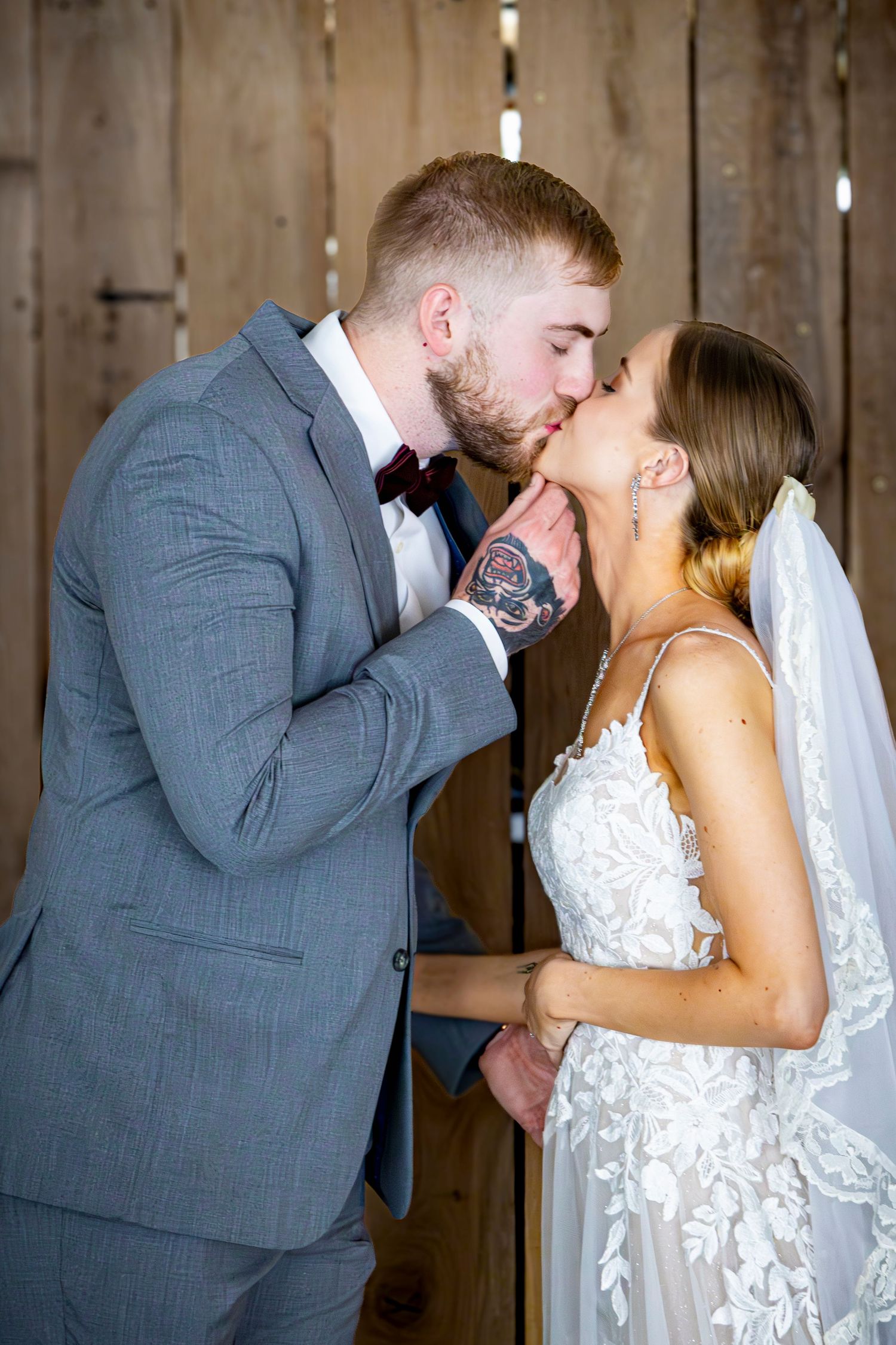 Romantic wedding moments captured inside rustic wooden barn setting.