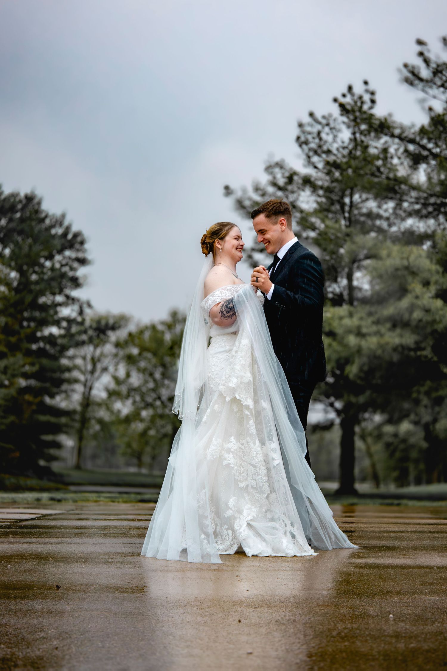 A couple shares an intimate moment during their wedding photoshoot in a park setting.