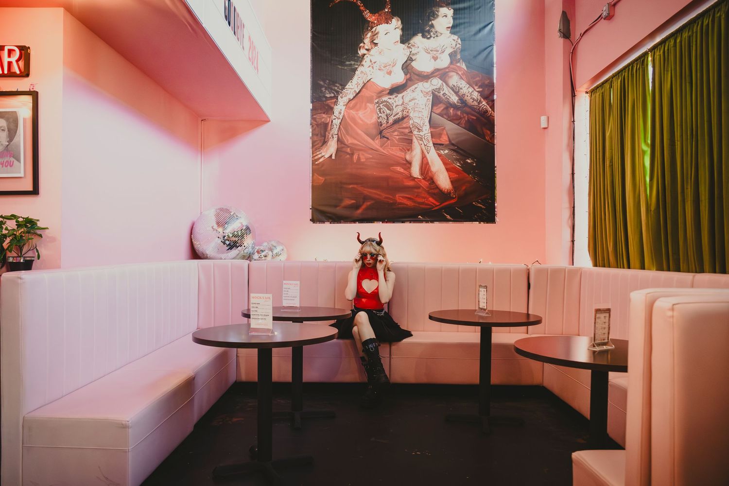 Pink-tinted interior space with vintage furniture and wall decorations.