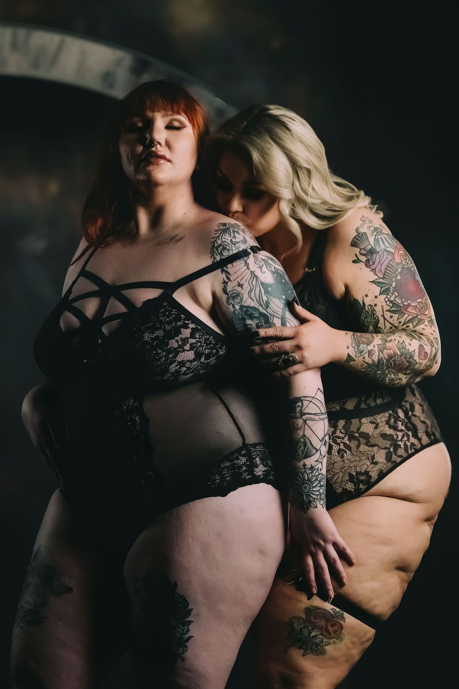 Intimate portrait series showcasing body art and lingerie in dramatic low-key lighting.