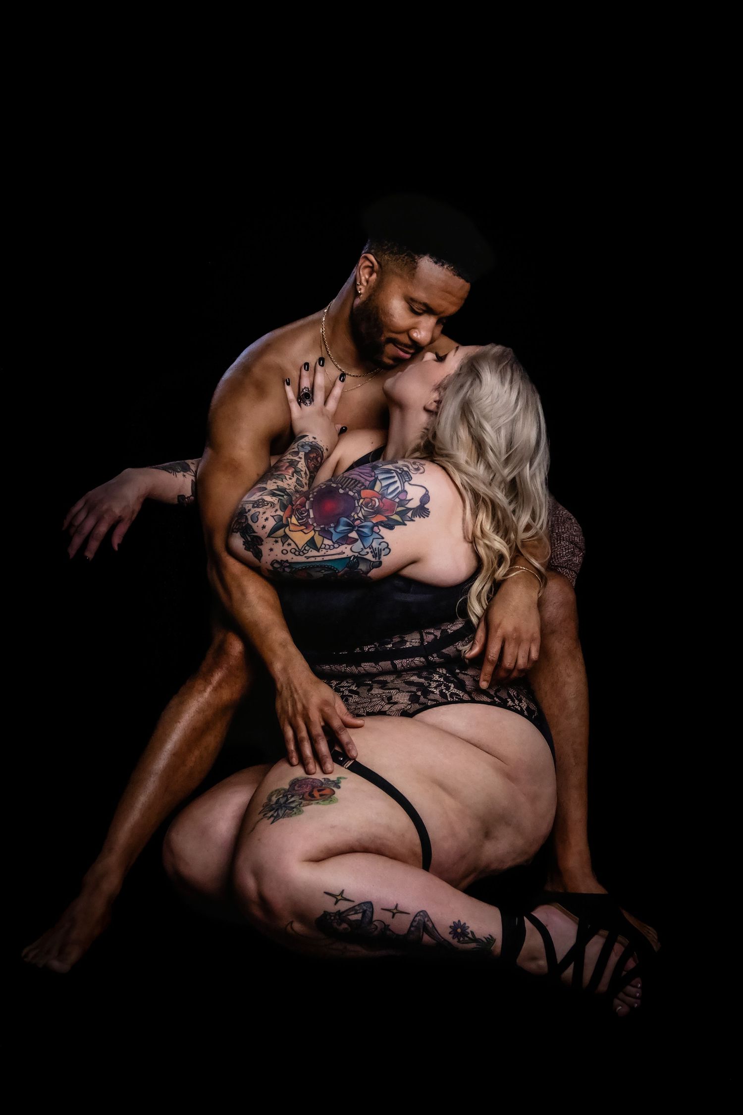 Intimate boudoir photography session featuring artistic poses and tattoo artwork.