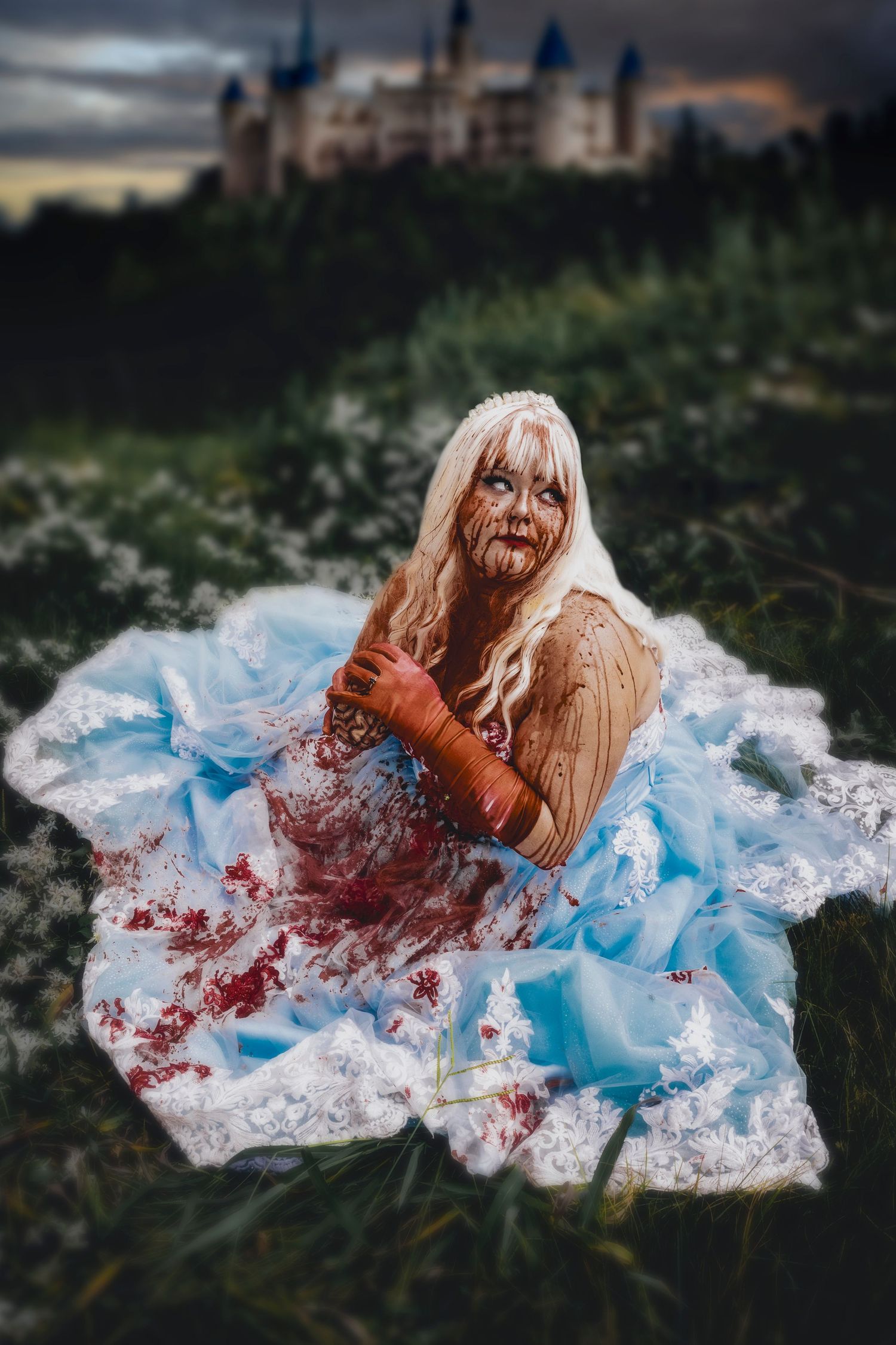 Gothic horror scene with blue dress and theatrical blood effects outdoors.