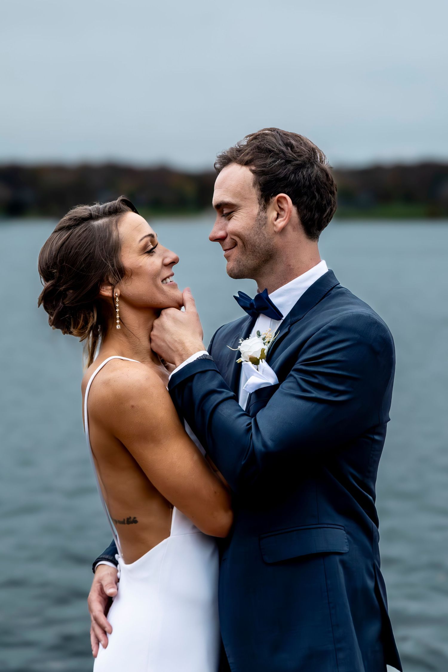 Romantic waterfront wedding photos showing couple in intimate embrace.