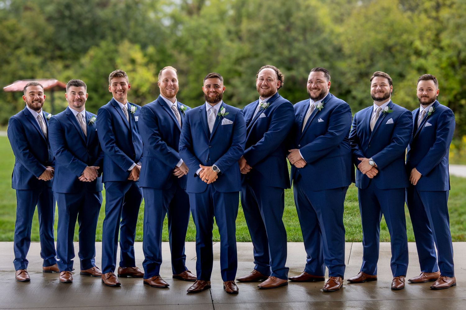 Groomsmen in navy suits and brown shoes lined up for creative wedding photo.