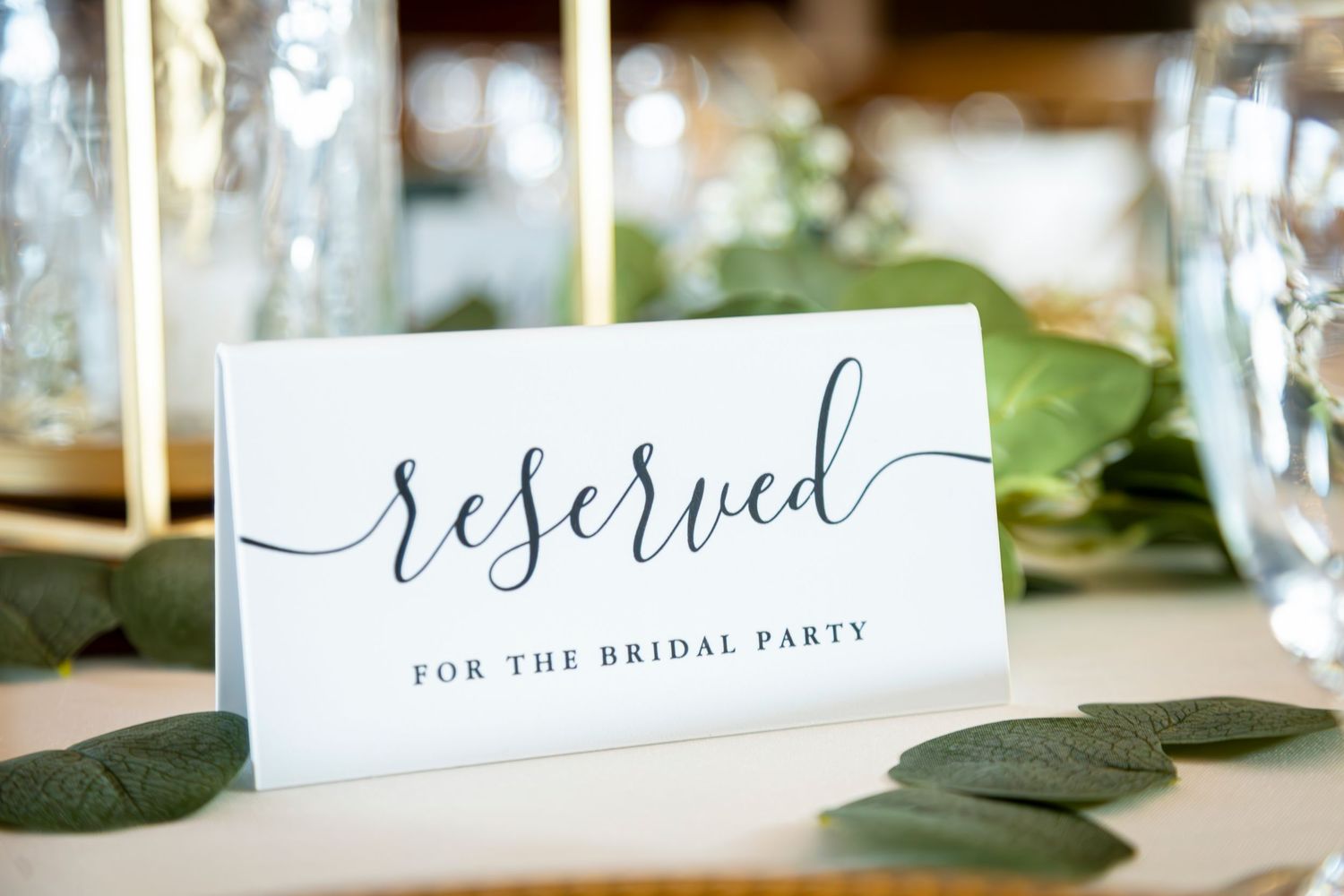 Elegant calligraphy place cards and decorative elements on a wedding reception table.