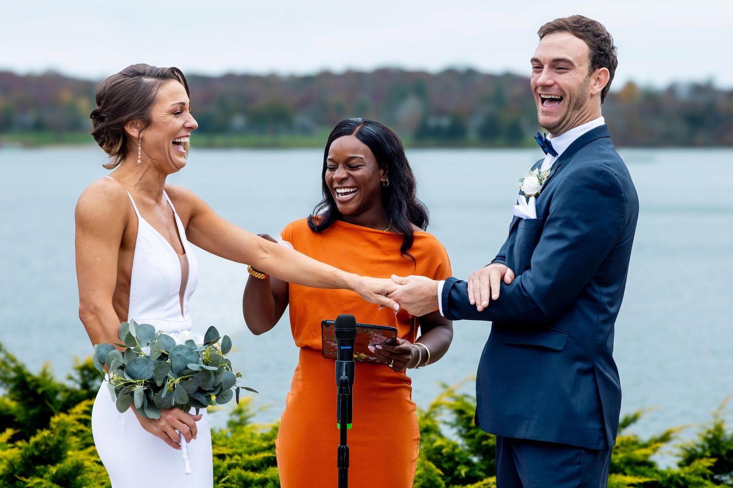 Wedding party members share celebratory moments by the water.