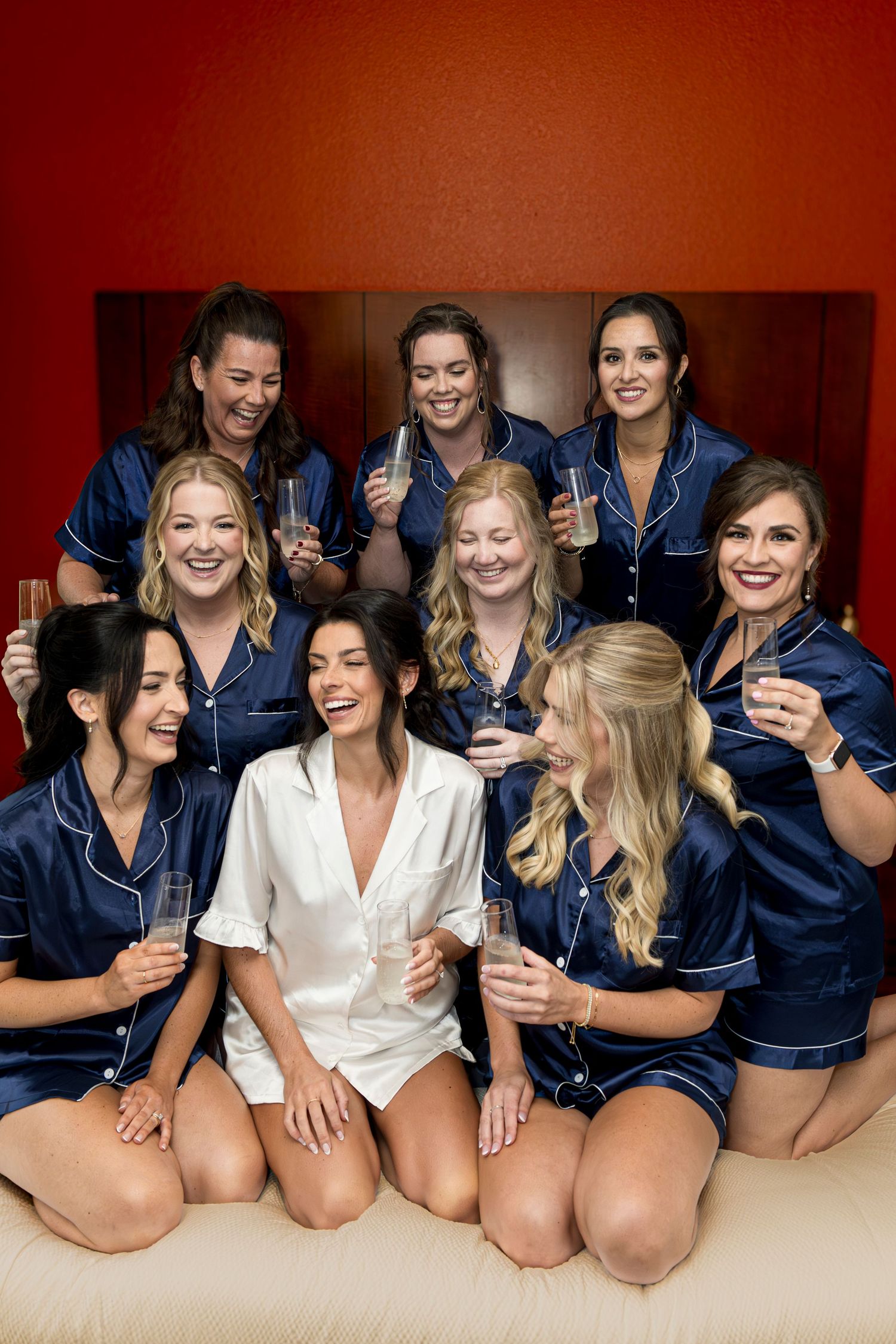 Wedding party in matching navy robes poses together during pre-ceremony preparations.