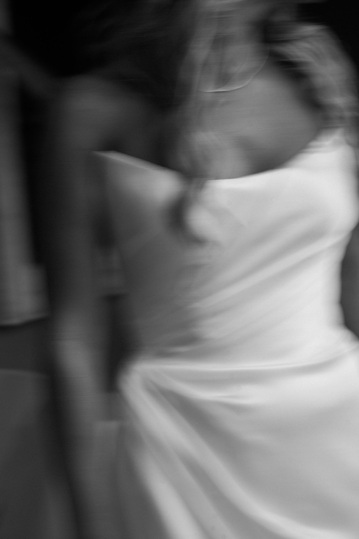 Abstract black and white motion blur captures movement of flowing white fabric.